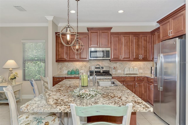 kitchen featuring light stone countertops, a kitchen breakfast bar, stainless steel appliances, pendant lighting, and an island with sink