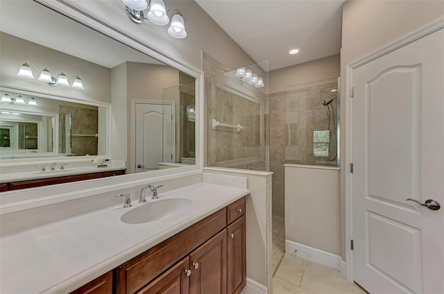 bathroom featuring tile patterned flooring, vanity, and tiled shower