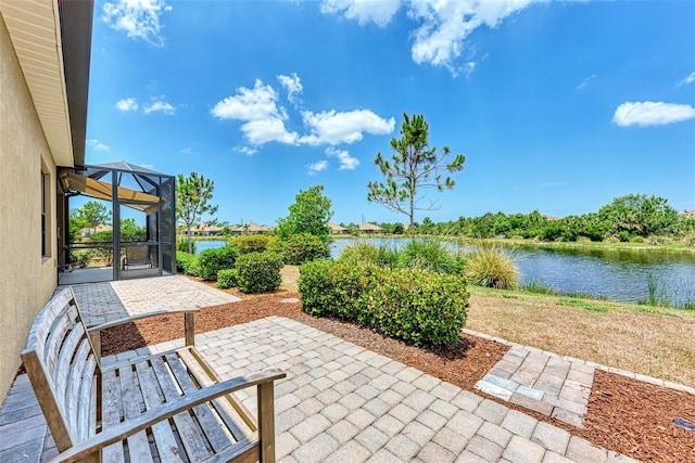 view of patio with a water view and a lanai