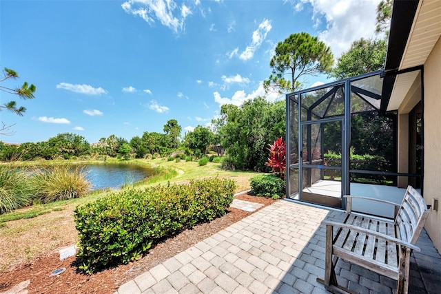 view of patio featuring a water view and glass enclosure