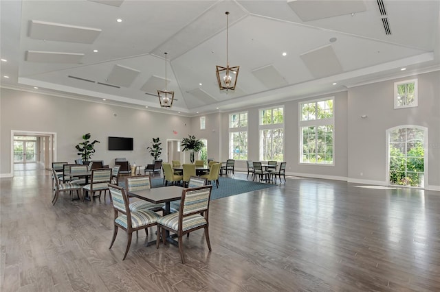 dining space featuring a notable chandelier, a healthy amount of sunlight, a high ceiling, and light hardwood / wood-style floors