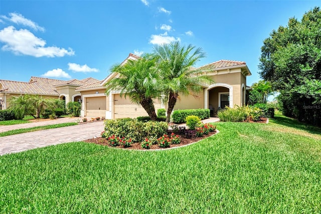 mediterranean / spanish-style house featuring a garage and a front yard