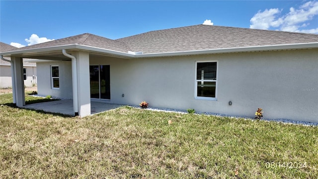 rear view of property featuring a yard and a patio