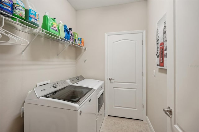 laundry room with separate washer and dryer and light tile flooring