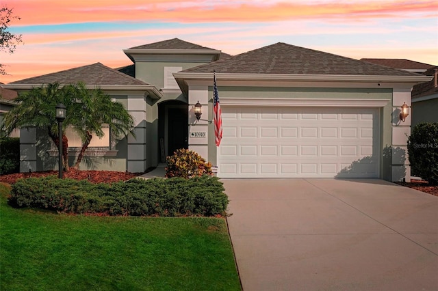 view of front of home featuring a garage and a yard