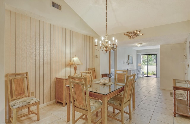 tiled dining room with a chandelier and vaulted ceiling