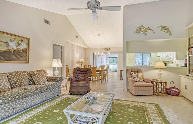 tiled living room with ceiling fan with notable chandelier and high vaulted ceiling