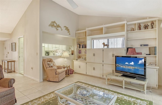 living area featuring ceiling fan, light tile patterned flooring, and vaulted ceiling