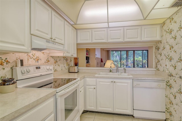 kitchen with light tile patterned flooring, white appliances, white cabinets, and sink