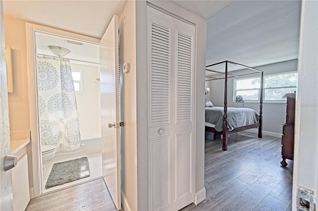 hallway featuring baseboards and hardwood / wood-style floors