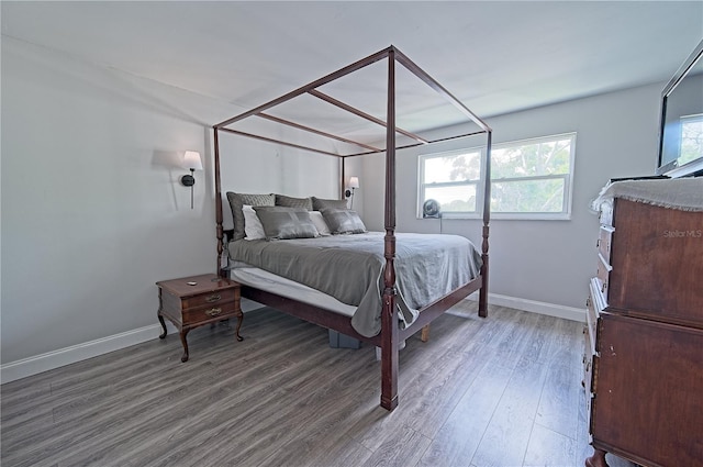 bedroom featuring light wood finished floors and baseboards