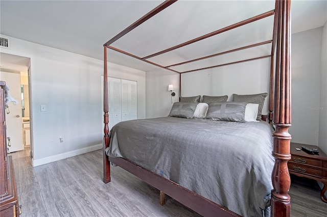 bedroom with a closet, baseboards, and wood finished floors