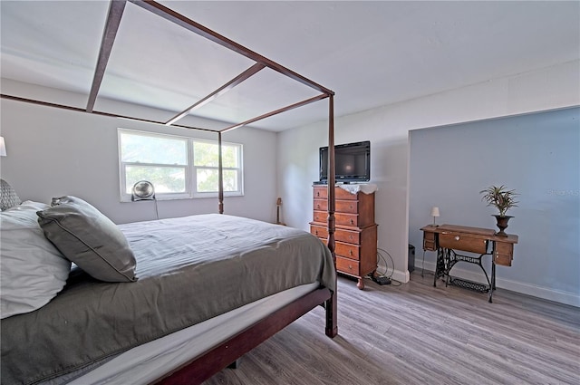 bedroom with wood finished floors and baseboards