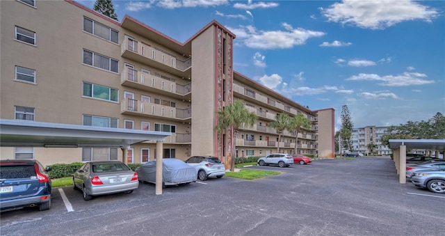 view of property with covered and uncovered parking