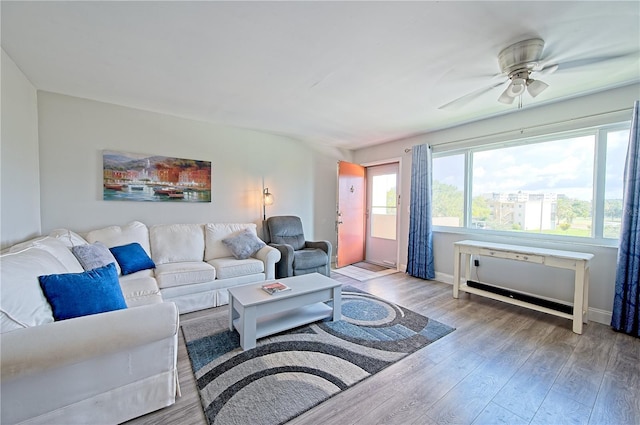 living room with wood finished floors, a ceiling fan, and baseboards