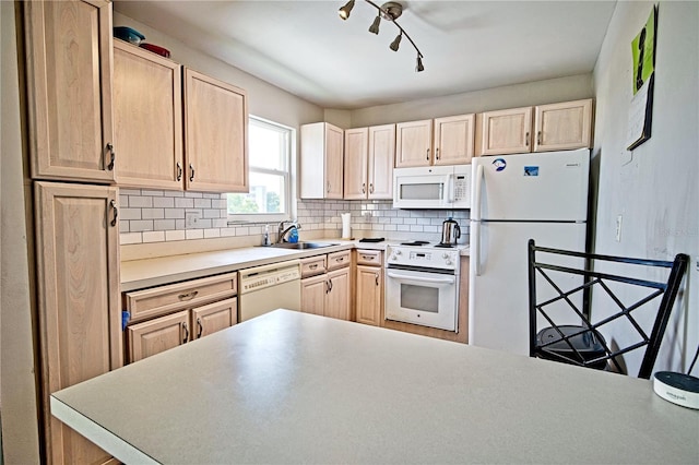 kitchen featuring white appliances, decorative backsplash, light countertops, light brown cabinets, and a sink