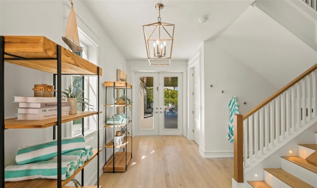 entrance foyer featuring a chandelier, light hardwood / wood-style flooring, and french doors