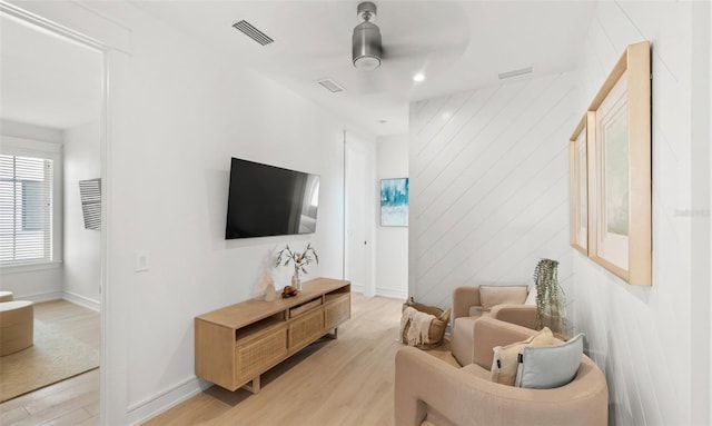 living room with light hardwood / wood-style flooring and ceiling fan