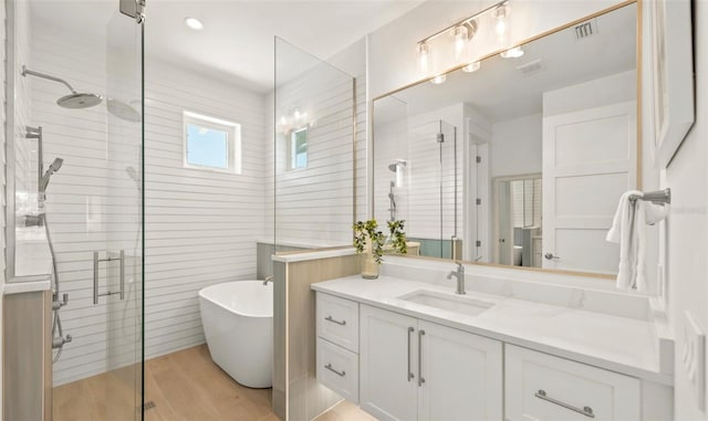 bathroom featuring hardwood / wood-style flooring, vanity, and independent shower and bath