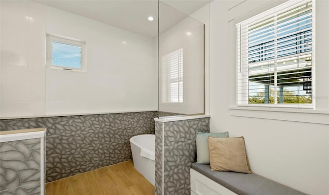 bathroom featuring hardwood / wood-style flooring, plenty of natural light, and a bathtub