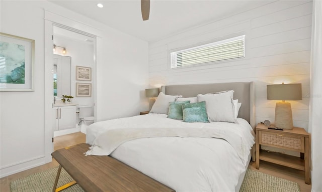 bedroom featuring ensuite bath, ceiling fan, and light hardwood / wood-style floors