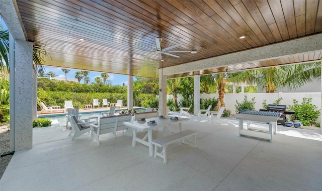 view of patio featuring a fenced in pool and ceiling fan