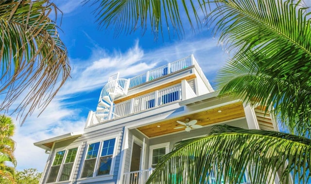 view of side of home featuring a balcony and ceiling fan