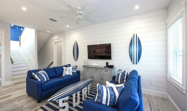 living room with plenty of natural light, ceiling fan, and light wood-type flooring