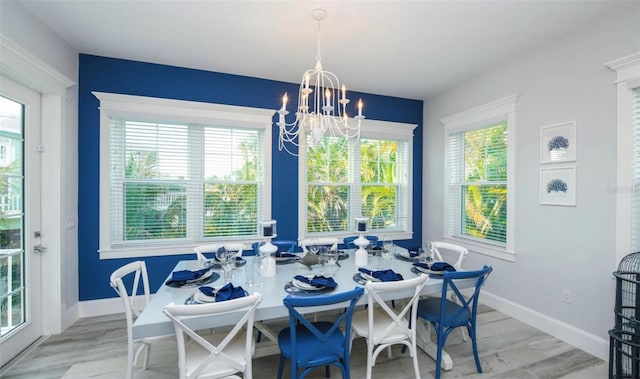 dining space with light wood-type flooring and a chandelier