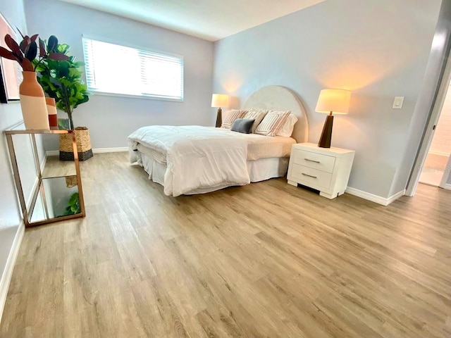 bedroom with wood-type flooring and connected bathroom