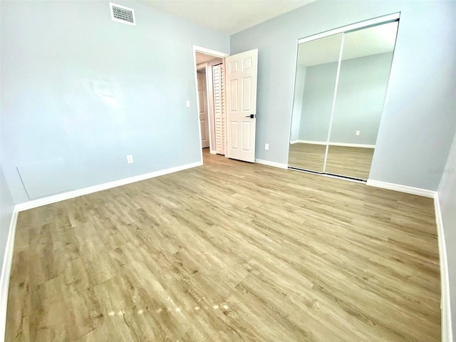 unfurnished bedroom with a closet and wood-type flooring