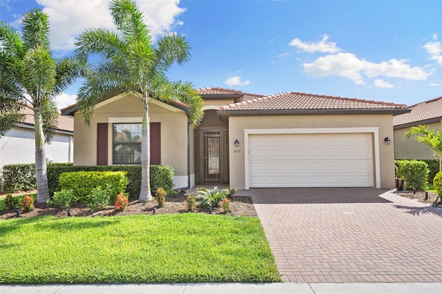 mediterranean / spanish-style home featuring a front yard and a garage