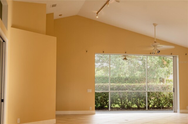 tiled empty room with ceiling fan and lofted ceiling