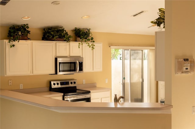 kitchen featuring stainless steel appliances, white cabinetry, and sink