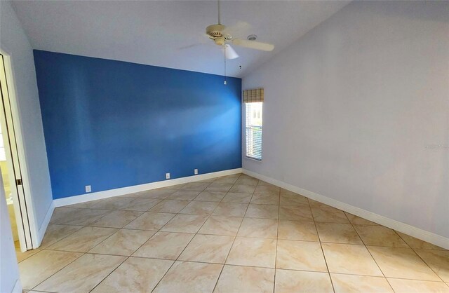 tiled empty room with ceiling fan and lofted ceiling