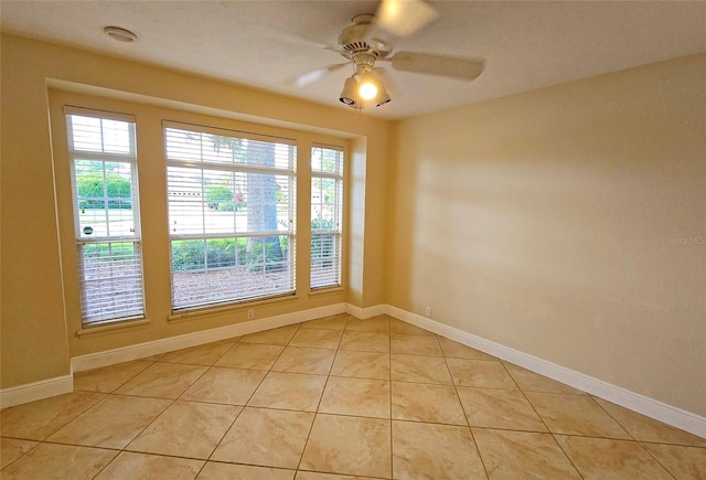 spare room with ceiling fan, a healthy amount of sunlight, and light tile patterned floors