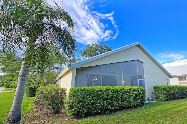 view of home's exterior featuring a lawn and a sunroom