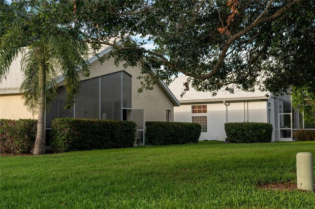 view of home's exterior with a yard and a sunroom