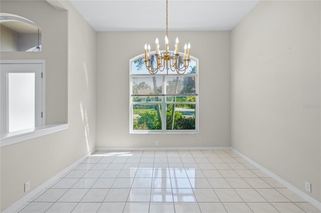 tiled spare room featuring a notable chandelier