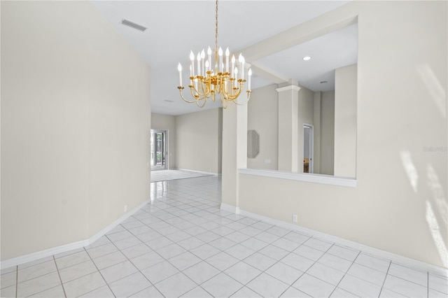 empty room featuring a notable chandelier and light tile patterned floors