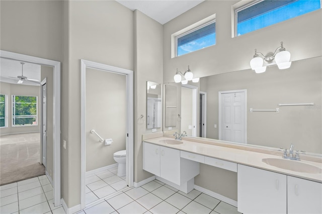 bathroom featuring ceiling fan, tile patterned floors, a towering ceiling, toilet, and vanity