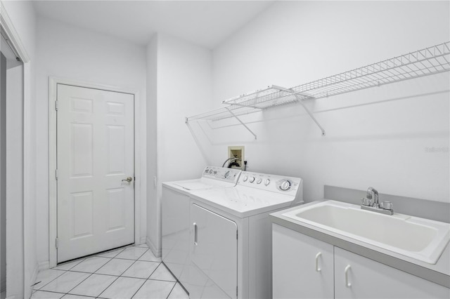 laundry area featuring washer and dryer, light tile patterned flooring, cabinets, and sink