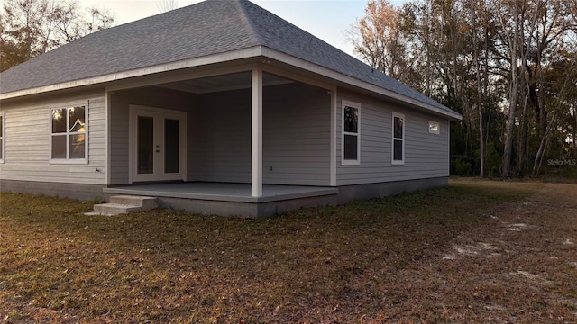 back of property with a yard and french doors