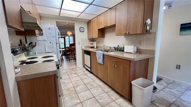 kitchen with sink, light tile floors, white appliances, and backsplash