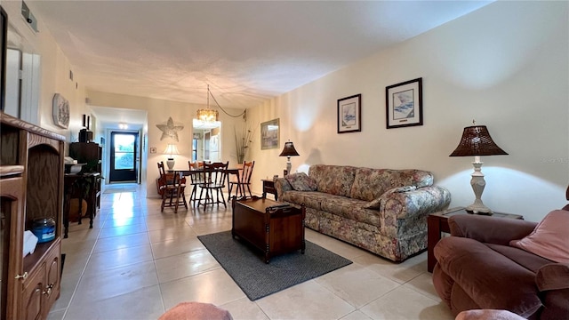 tiled living room with a notable chandelier