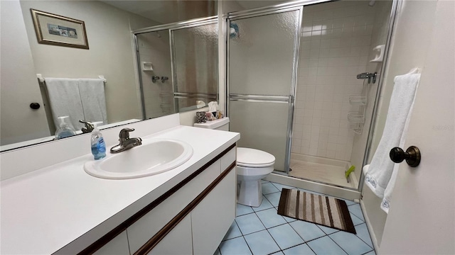 bathroom with tile flooring, a shower with shower door, oversized vanity, and toilet