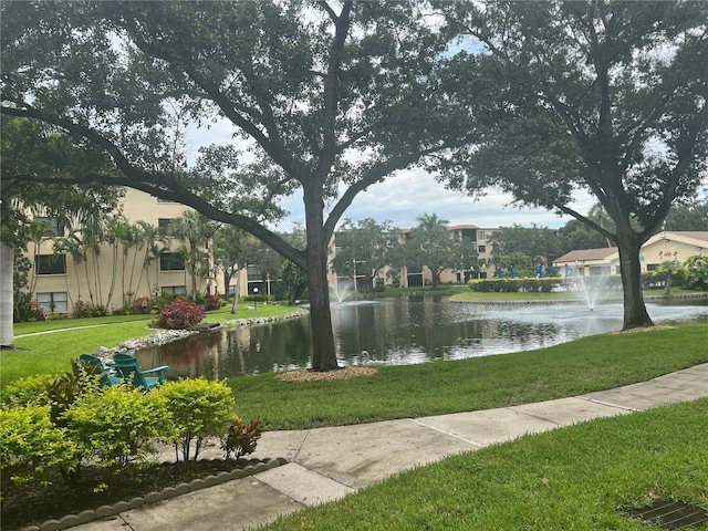 view of community with a water view and a yard