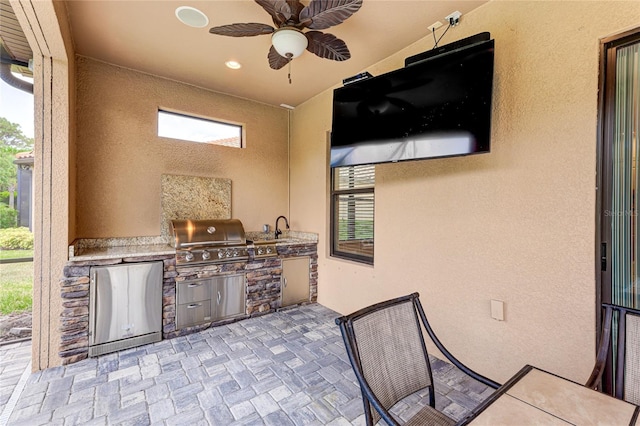 view of patio / terrace featuring ceiling fan, area for grilling, exterior kitchen, and sink