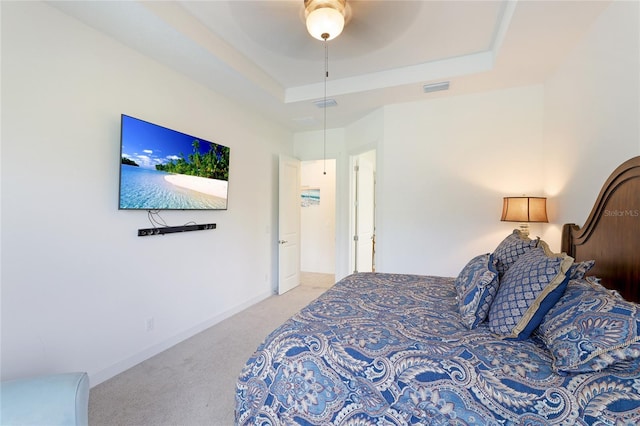 bedroom with carpet flooring, ceiling fan, and a tray ceiling