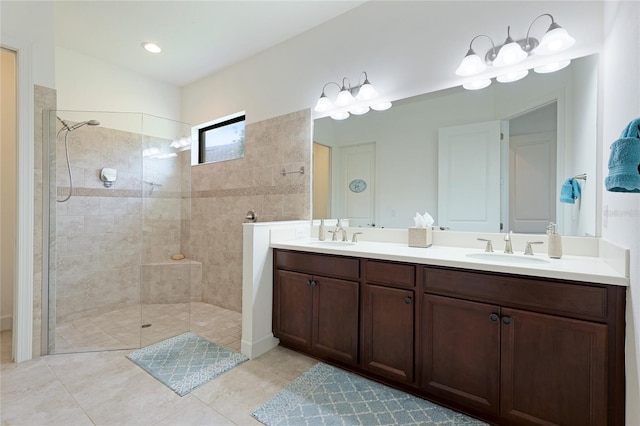 bathroom featuring a tile shower, tile patterned floors, and vanity